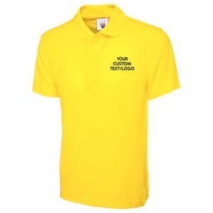 May include: A vibrant yellow polo shirt with a collared neckline and short sleeves. The shirt has the text "YOUR CUSTOM TEXT/LOGO" in black on the chest. The fabric appears to be smooth.