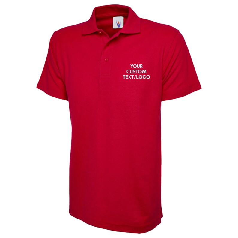 May include: A red polo shirt with short sleeves and a collared neckline. The shirt has the text "YOUR CUSTOM TEXT/LOGO" in white on the chest. The shirt is made of a smooth fabric, suitable for casual wear.