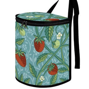 May include: A cylindrical cooler bag with a black zipper and strap. The bag features a repeating pattern of red strawberries, green leaves, and white flowers on a light blue background. The strap is black.