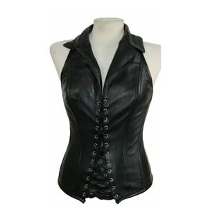 May include: Black leather halter top with a collared neckline and a lace-up front. The top is fitted and has a corset-like design. The garment is displayed on a white mannequin against a white background.