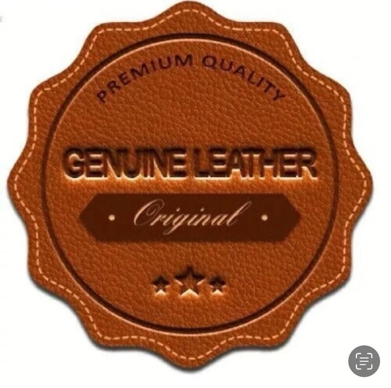 May include: A brown, scalloped-edge circular leather patch featuring a textured surface. The text reads PREMIUM QUALITY, GENUINE LEATHER, and Original, with three small stars centered at the bottom. The design includes decorative stitching.