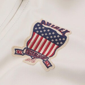 May include: A white leather jacket with a patriotic patch. The patch features the words "AVIREX" and "NY ESTABLISHED 1975" with a design of the American flag. The patch is in red, white, and blue.