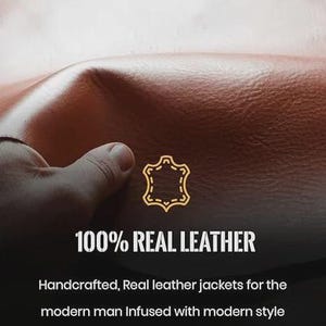 May include: Close-up of brown leather with the text "100% REAL LEATHER". The image shows a hand touching the leather. The text below reads "Handcrafted, Real leather jackets for the modern man Infused with modern style and a touch of luxury."