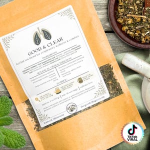 May include: A package of "GOOD & CLEAR" herbal tea blend for respiratory wellness and comfort. The label lists ingredients like peppermint leaf and chamomile flower. The package is brown with white text and a graphic of lungs.