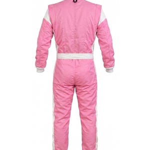May include: Pink racing suit with white accents. The suit features a white collar, cuffs, and side stripes. A white belt cinches the waist. The suit is designed for motorsports and is made of a durable, quilted material.
