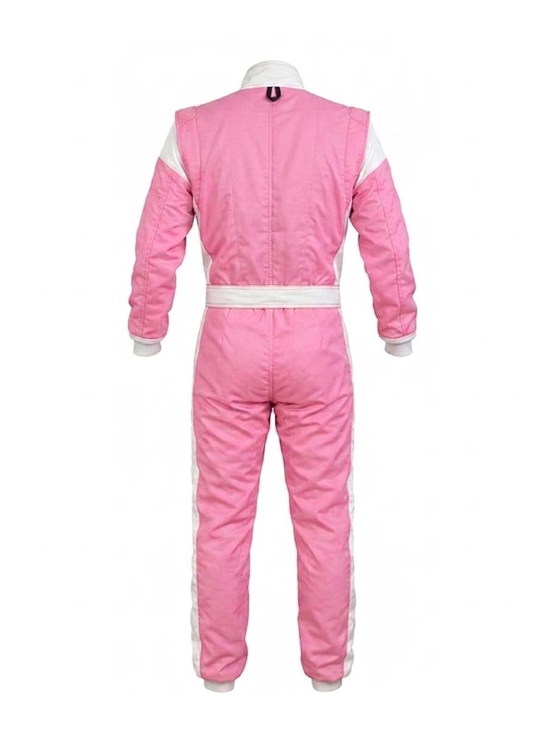 May include: Pink racing suit with white accents. The suit features a white collar, cuffs, and side stripes. A white belt cinches the waist. The suit is designed for motorsports and is made of a durable, quilted material.