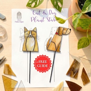 以下が含まれることがあります： 「Cat & Dog Plant Stakes」の文字が入ったシートと、猫と犬のステンドグラスのプランター用杭が2つ。猫は黄色と白、犬は茶色です。シートには「+ FREE GUIDE」の文字も入っています。