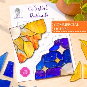 Op de afbeelding: Een papieren patroon voor hemelse boekensteunen met de tekst "Celestial Bookends" en "Glass Patternique". Twee glas-in-loodstukken liggen erbovenop: één in geel- en oranjetinten, en één in blauw- en paarstinten. Bevat een "COMMERCIAL LICENSE"-label en een "+ FREE GUIDE"-badge.