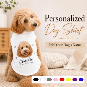 Peut inclure: Un t-shirt blanc sans manches pour chien avec l'illustration d'un visage de chien doodle brun doré, le nom Charlie imprimé en dessous et des petits cœurs. Le texte Personalized Dog Shirt et Add Your Dog's Name sont visibles.