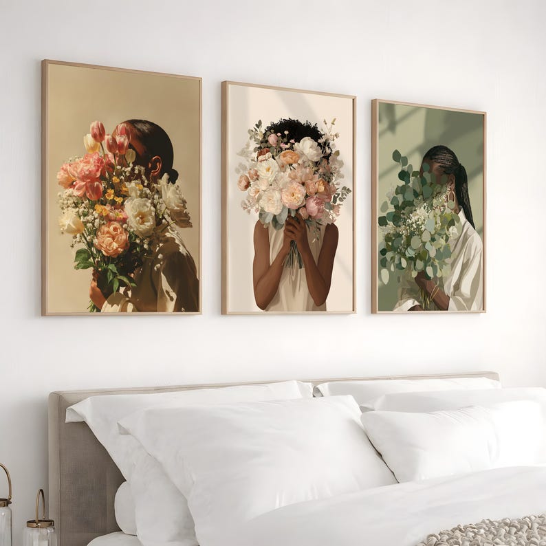 May include: Three framed art prints featuring illustrations of figures holding bouquets of flowers. The artwork has a neutral color palette with beige, peach, and green tones. The figures' faces are obscured by the flowers, creating a sense of mystery.