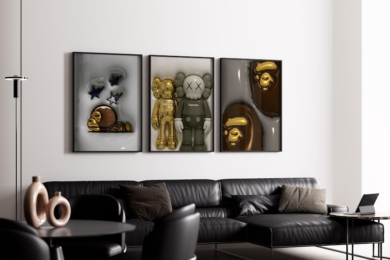 Puede incluir: Un conjunto de tres l&aacute;minas de arte enmarcadas. La l&aacute;mina izquierda muestra un personaje de mono marr&oacute;n con estrellas. La central presenta dos figuras, una dorada y otra gris con ojos en forma de X. La derecha muestra dos caras de mono brillantes.