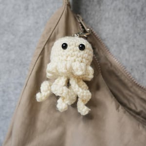 May include: A set of three ceramic mugs with a speckled, matte finish in cream, light grey, and dark grey. Each mug has a simple, minimalist design, ideal for coffee or tea.