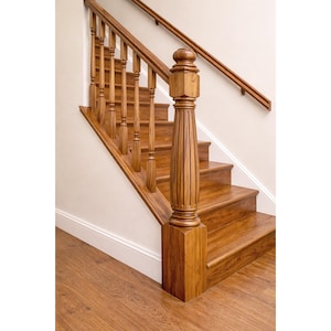 Könnte beinhalten: Eine Holztreppe mit warmer, natürlicher Oberfläche. Die Treppe verfügt über ein Geländer mit gedrechselten Balustern und einen massiven Pfosten. Handlauf und Stufen sind aus dem gleichen Holz gefertigt, was ein stimmiges Design ergibt. Der Boden ist ebenfalls aus Holz.