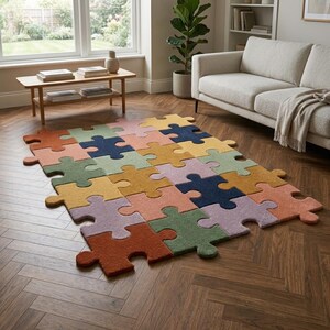 May include: A colorful puzzle-shaped rug with various pastel colors, including orange, green, yellow, pink, and blue. The rug is placed on a wooden floor in a living room setting, with a couch and a coffee table visible in the background.