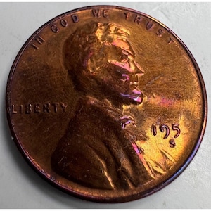 May include: A copper-colored 1955 S Lincoln cent coin. The obverse features a profile of Abraham Lincoln, the word "LIBERTY", and the inscription "IN GOD WE TRUST". The coin has a slight iridescent sheen.