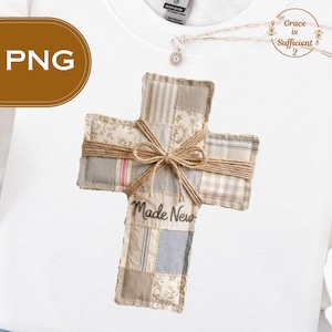 以下が含まれることがあります： ベージュ、グレー、ブルーの様々な生地パターンが特徴の、ジュートのリボンと紐が付いたパッチワークの十字架。「Made New」の文字が下部に書かれています。宗教的なアイテムです。