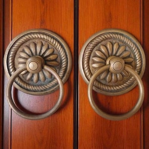 Puede incluir: Una taza de cerámica blanca con asa negra y el texto "But First, Coffee" en estilo manuscrito. La taza está sobre una superficie blanca. Para bebidas calientes.