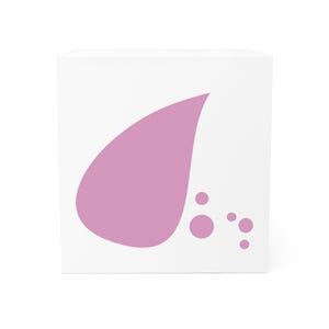 May include: A white cube with a large, light purple teardrop shape and three smaller circles on one side. The design is simple and modern, with a minimalist aesthetic. The shapes are solid and opaque.