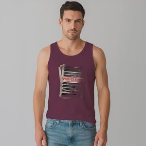 Peut inclure: Un débardeur bordeaux avec un graphisme d'une pile de papiers et le texte "PROFFER AT 100" dans un rectangle rouge. Le débardeur est porté par une personne en jean bleu.