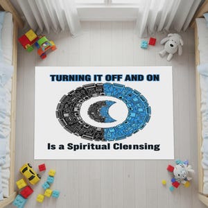 May include: White rectangular rug with the text "TURNING IT OFF AND ON Is a Spiritual Cleansing". The rug features a circular design in black and blue, composed of various electronic components. Toys are scattered around the rug.