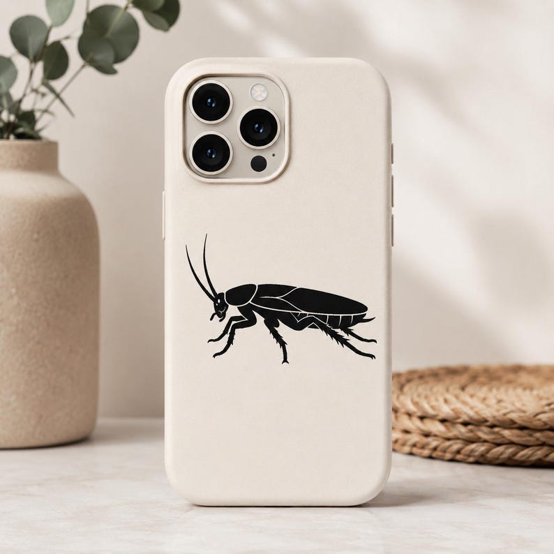 Op de afbeelding: Een matte, cr&egrave;mekleurige smartphonehoes met een gecentreerde, effen zwarte grafische illustratie van een kakkerlak in profiel. De hoes heeft een rechthoekige camera-uitsparing aan de linkerbovenkant met drie cirkelvormige lenzen.