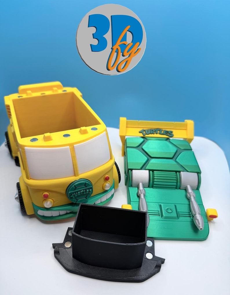 Pode incluir: Conjunto de ve&iacute;culos de brinquedo impressos em 3D com uma carrinha amarela e branca, um componente de ve&iacute;culo verde e amarelo e uma pe&ccedil;a retangular preta. A carrinha tem um design de rosto sorridente. O componente verde tem a palavra "TURTLES".
