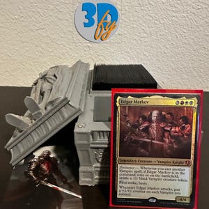 May include: A gray 3D-printed card holder with a red-bordered Edgar Markov card. A small figurine of a vampire knight with a sword is in front of the holder. The 3Dby logo is in the background.