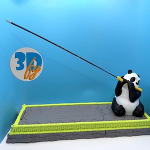 May include: A black and white panda figurine holding a yellow and black incense stick. The panda is on a gray platform with a green border. The background is blue, and a logo with the text "3D by" is visible.