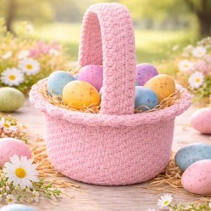 Könnte beinhalten: Ein rosa gehäkelter Osterkorb gefüllt mit bunten, gesprenkelten Eiern. Der Korb steht auf einer Holzoberfläche, umgeben von Gänseblümchen und weiteren Eiern. Die Eier sind blau, gelb, rosa und lila.