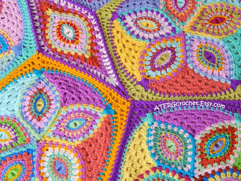 May include: A colorful crochet blanket with a geometric pattern featuring various shades of pink, purple, blue, green, yellow, and orange. The blanket is made up of multiple squares with intricate designs.