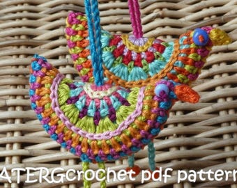 May include: Two colorful crocheted birds with beaded accents hanging from a wicker background. The birds are made with a variety of bright colors, including pink, orange, yellow, green, blue, and purple. The text "ATERGcrochet pdf pattern" is visible at the bottom of the image.