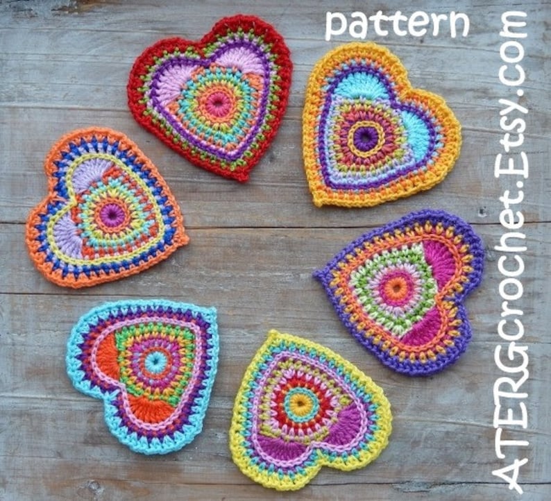 May include: Six crocheted hearts in various colors, including red, orange, yellow, green, blue, and purple. Each heart has a circular pattern in the center and is made with a variety of colorful yarns.