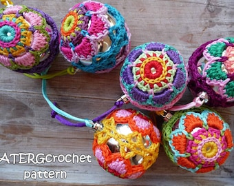 May include: Six colorful crocheted ornaments with a variety of floral patterns. The ornaments are made with a combination of pink, purple, green, yellow, and orange yarn. The ornaments are hanging from a wooden surface. ATERGcrochet pattern.