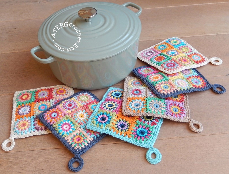 May include: Five crocheted pot holders with colorful square patterns and a loop handle. The pot holders are arranged in a row, with the largest one at the top and the smallest one at the bottom. The pot holders are made with a variety of colors, including red, orange, yellow, green, blue, and purple. The pot holders are made with a variety of stitches, including single crochet, double crochet, and treble crochet. The pot holders are a great way to add a touch of color and style to your kitchen.