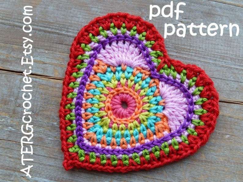 May include: A colorful crocheted heart with a multi-colored center and a red border. The heart is on a wooden surface. The text "pdf pattern" is written above the heart. The text "ATERcrochet.Etsy.com" is written to the left of the heart.