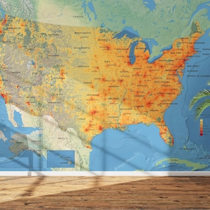 May include: A large wall map of the United States, showing population density with a colour gradient from yellow to red. The map is detailed with state names and major cities. A potted plant sits to the right.