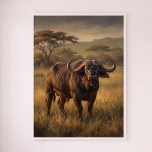 Può includere: Una stampa artistica da parete incorniciata raffigurante un bufalo africano marrone scuro in piedi in una savana erbosa dorata. La scena include acacie sparse sotto un cielo morbido e nuvoloso, catturando l'animale in un paesaggio naturale aperto.