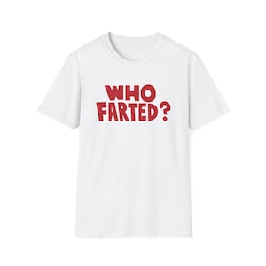 May include: A white short-sleeved t-shirt featuring the text WHO FARTED? printed in bold red capital letters across the centre of the chest. The garment has a standard crew neckline and a straight hemline, constructed from a plain white fabric.
