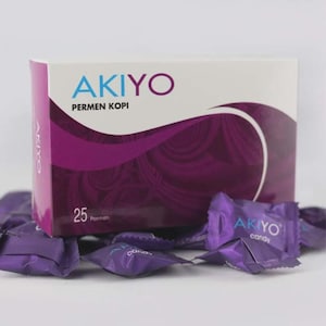 Puede incluir: Una caja blanca de caramelos de café AKIYO con detalles y texto morados. La caja está rodeada de envoltorios individuales de caramelos morados. La caja dice "AKIYO PERMEN KOPI" y "25 Permen".