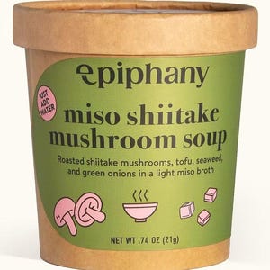 Könnte beinhalten: Ein brauner Pappbecher mit Epiphany Miso-Shiitake-Pilzsuppe. Das grüne Etikett enthält den Text "Just Add Water" und "miso shiitake mushroom soup". Das Nettogewicht beträgt 21g.