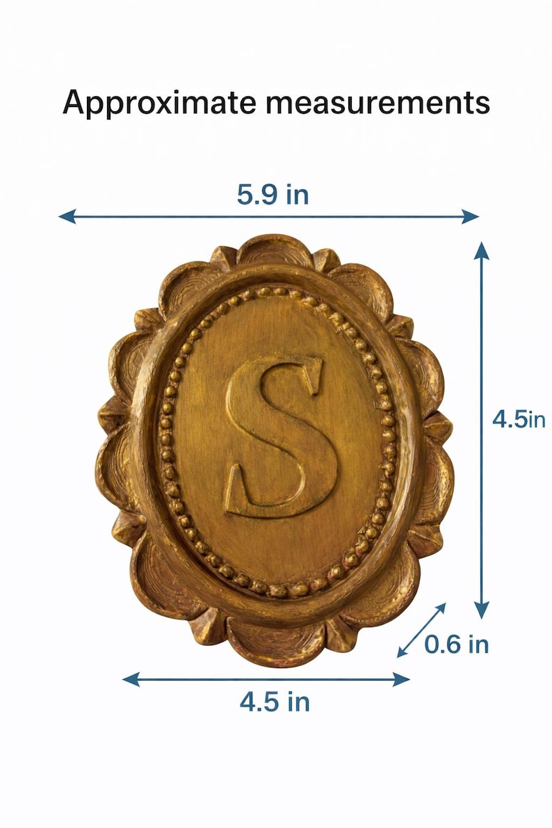 May include: An oval gold-colored plaque featuring a raised letter S in the center, surrounded by a beaded border and a scalloped edge. The plaque has approximate measurements of 5.9 inches in width, 4.5 inches in height, and 0.6 inches in depth.