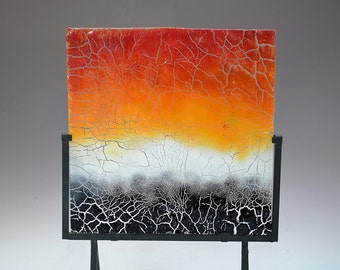 May include: Abstract art piece featuring a square panel with a vibrant color gradient. The top transitions from red to orange, fading into white, and then black at the bottom. The panel is supported by a black metal stand.