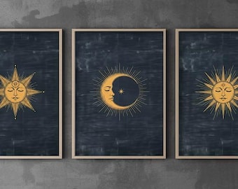 May include: A set of three framed wall art prints featuring gold celestial illustrations on a dark navy blue textured background. The outer prints display a sun with a face, while the centre print depicts a crescent moon with a face and rays.