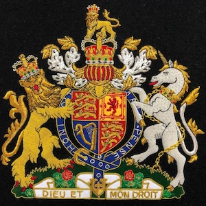 以下が含まれることがあります： 金色のライオンと白いユニコーンが、赤、青、黄色の要素を持つ盾を挟んだ刺繍入りの紋章。紋章には王冠、テキスト入りのバナー、黒い背景が含まれています。