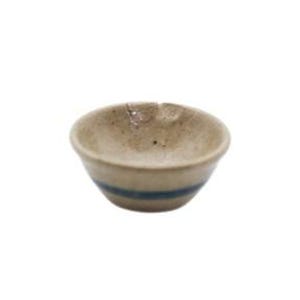 May include: A small, round, beige ceramic bowl with a speckled texture and a single horizontal dark blue stripe encircling the exterior. The rim features a small, subtle indentation or notch on the upper edge, and the interior is smooth.