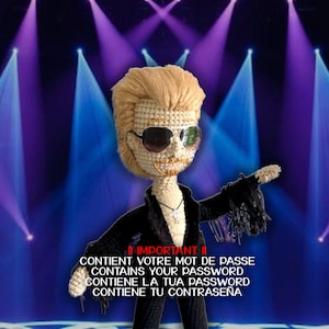 Peut inclure: Poupée au crochet de Mini Johnny Hallyday, portant des lunettes de soleil et une tenue noire, sur une scène avec des lumières violettes et bleues. La poupée a des cheveux blonds et un collier en forme de croix. Le texte dit "IMPORTANT" et des phrases liées aux mots de passe.