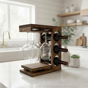 May include: A dark brown wooden wine rack featuring a vertical side panel with three circular cutouts for holding wine bottles horizontally. The top section includes a hanging rack for four clear glass wine glasses and a flat base platform.