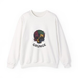 Può includere: Felpa bianca con un design a teschio colorato con accenti rossi, gialli, verdi e blu. La parola "GRUNGE" è stampata in nero sotto. La felpa ha maniche lunghe e girocollo.