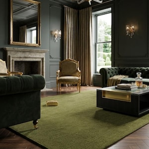 May include: An interior shot of a luxurious living room with dark green walls and a matching green rug. The room features a tufted green sofa, a gold-framed mirror, and a chandelier. A dark wood coffee table sits on the rug.