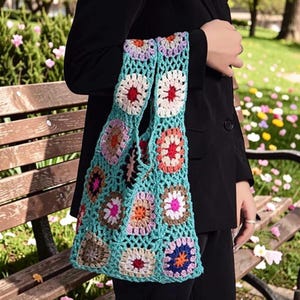 Peut inclure: Une tasse en céramique blanche avec une anse noire et le texte "But First, Coffee" en gras noir. La tasse est posée sur un fond flou, suggérant un cadre chaleureux.